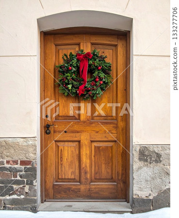 A Christmas wreath decorated on a simple wooden door 133277706