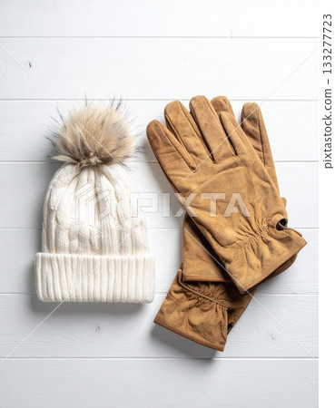 Gloves and a scarf on a white wooden table 133277723
