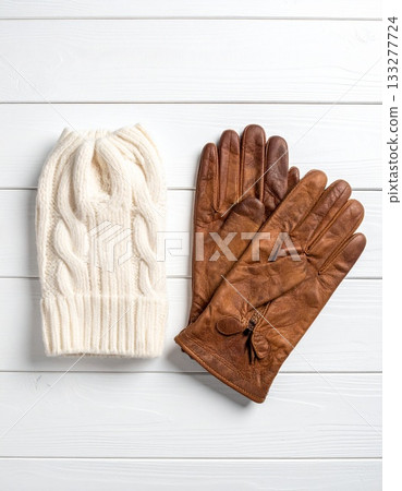 Gloves and a scarf on a white wooden table 133277724