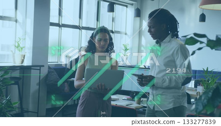 Office woman wearing business attire reviewing laptop in lounge area, with smartphone and notebooks 133277839
