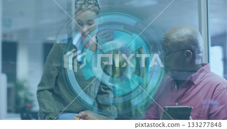 Collaborating woman and senior man using holographic interface at office desk, with tablet and pen 133277848