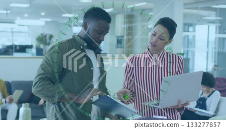 Reviewing professionals pointing at open document folder in modern office, with laptop 133277857