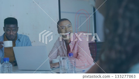 Smiling woman in pink striped blouse sitting at table in meeting room, with laptop, coffee mug 133277863