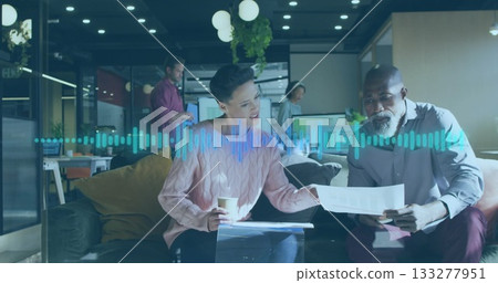 Reviewing printed documents, two professionals collaborating in office lounge, with coffee cup Reviewing printed documents, two professionals collaborating in office lounge, with coffee cup 133277951