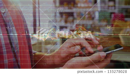 Tapping smartphone at cafe table with hands in red blue plaid shirt, overlaying financial graphs 133278028