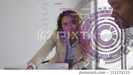 Woman wearing blazer leaning on office table pointing at laptop showing code and circular graphics Woman wearing blazer leaning on office table pointing at laptop showing code and circular graphics 133278153