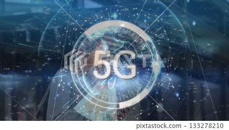 Woman in business attire holding smartphone, viewing holographic 5G globe and data nodes in office 133278210