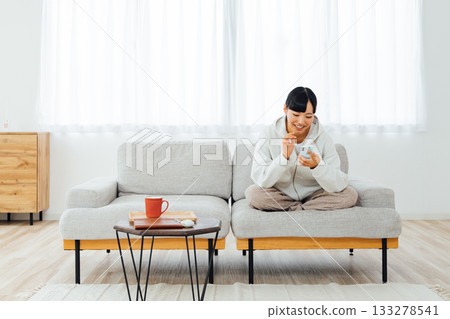 一位女士在房間放鬆地使用智慧型手機 133278541