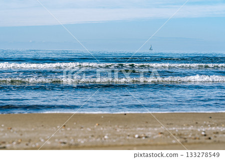 平靜的海面和遠處的遊艇 133278549