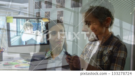 Showing plaid-clad woman holding smartphone at office desk with monitor sticky notes, copy space 133278724
