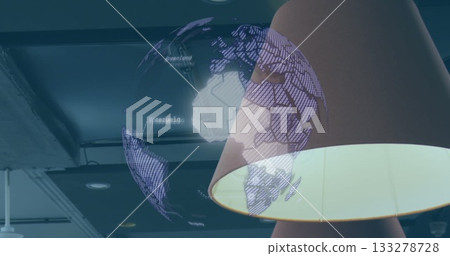 Projecting digital globe hologram over conical lamp shade in lounge: ceiling beams, recessed lights Projecting digital globe hologram over conical lamp shade in lounge: ceiling beams, recessed lights 133278728