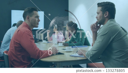 Discussing two businessmen facing each other at office meeting table, reviewing world map overlay 133278805
