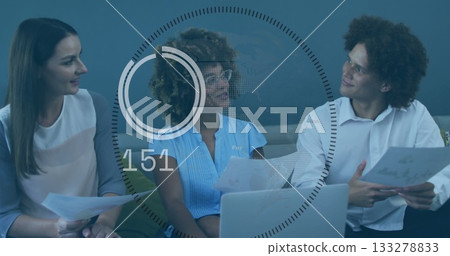 Reviewing three professionals analyzing documents in office lounge, with laptop and data graphic Reviewing three professionals analyzing documents in office lounge, with laptop and data graphic 133278833