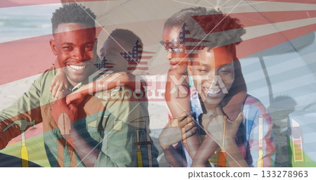 Smiling parents holding kids on shoulders under striped umbrella at shore, with Labour Day overlay 133278963