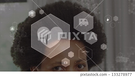 Displaying African American woman viewing medical interface with floating hexagonal icons 133278977