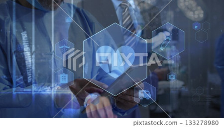 Collaborating clinical team in scrubs examining holographic icons on tablet, with stylus in lab 133278980