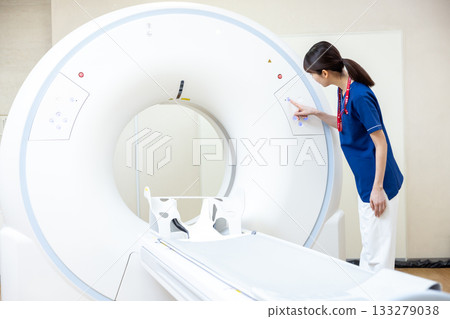 一名放射科醫生站在 CT 掃描前。照片由東京電子專門學校電波學園提供。 133279038
