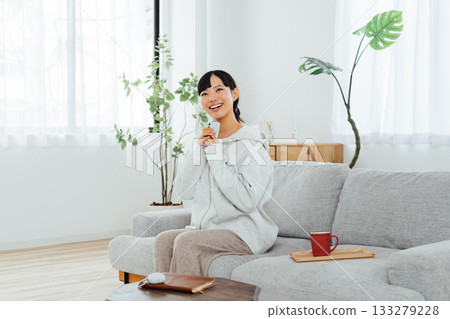 一位女士在房間放鬆地使用智慧型手機 133279228