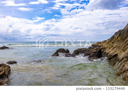 Rocky beach with rocks waves turquoise water in Patong Thailand. 133279440