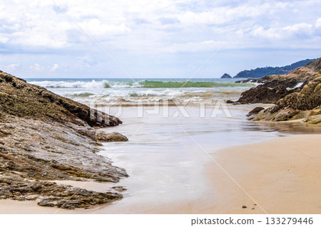 Rocky beach with rocks waves turquoise water in Patong Thailand. Rocky beach with rocks waves turquoise water in Patong Thailand. 133279446