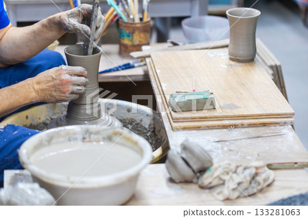 The rope craftsman is focused on making traditional pottery. The rope craftsman is focused on making traditional pottery. 133281063