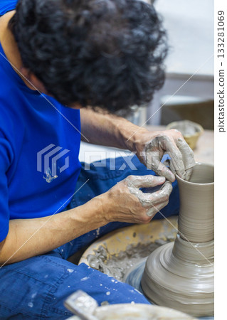 The rope craftsman is focused on making traditional pottery. 133281069