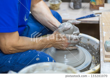 The rope craftsman is focused on making traditional pottery. 133281070