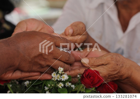 Close - up of hands of Thai pour water on elders' hands for blessings, Songkran Festival Close - up of hands of Thai pour water on elders' hands for blessings, Songkran Festival 133281074