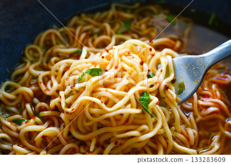 Instant noodles on fork in a bowl.  133283609