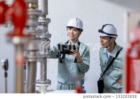 Building maintenance: A woman inspecting equipment. Photo courtesy of Denpa Gakuen, Tokyo Electronics College. 133283838
