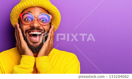 Brightly dressed man expresses joy with excitement against a vibrant purple background during a cheerful moment in a lively setting 133284082