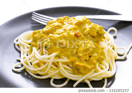 Chicken curry spaghetti with fork on a plate. Chicken curry spaghetti with fork on a plate. 133285257