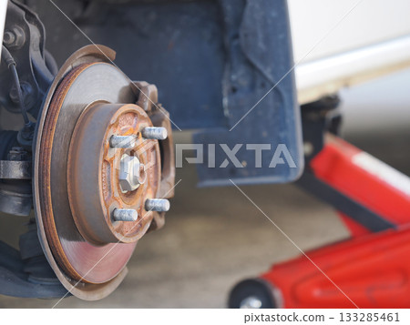 用千斤頂頂起汽車並卸下輪胎 用千斤頂頂起汽車並卸下輪胎 133285461