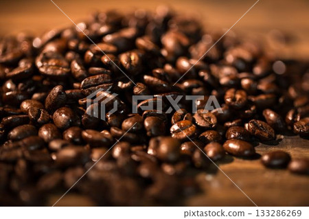 Glossy roasted coffee beans are glistening on warm wooden tabletop in flat design 133286269