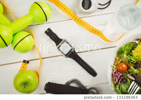 Overhead view of smart watch and dumbbells 133286363