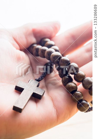 Hand holding rosary beads Hand holding rosary beads 133286689