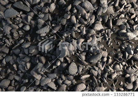Flat design showing dense grey stones and pebbles covering dark soil with subtle shadows 133286771