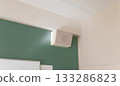 A white speaker installed in the corner near the ceiling of a school classroom 133286823