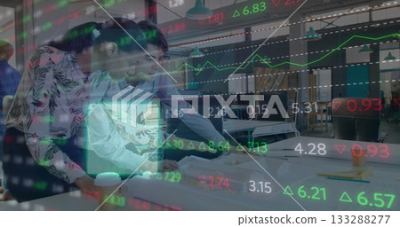 Leaning colleagues examining printed documents and typing on laptop in office, stock market overlay Leaning colleagues examining printed documents and typing on laptop in office, stock market overlay 133288277