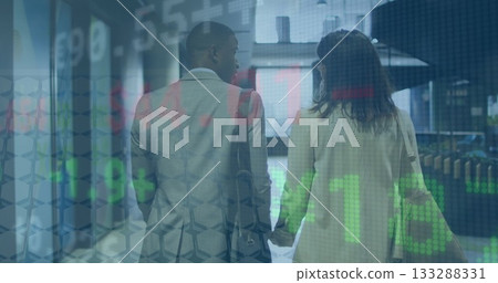 Walking business couple in suits holding hands in corridor carrying bag, with stock market overlay 133288331