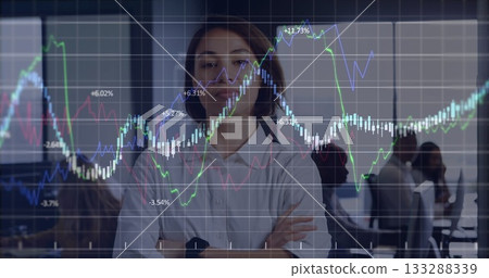 Standing woman wearing white shirt and smartwatch observing colleagues at office, financial overlay Standing woman wearing white shirt and smartwatch observing colleagues at office, financial overlay 133288339
