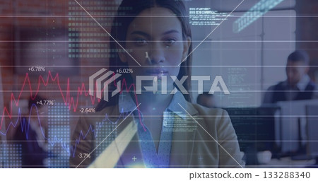 Displaying female business professional visualizing financial charts in open office, with monitors Displaying female business professional visualizing financial charts in open office, with monitors 133288340