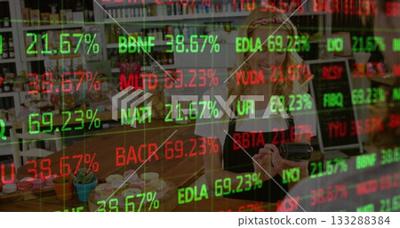 Bakery cashier processing card payment at cafe counter, with cupcakes, overlaying stock ticker data 133288384