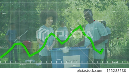 Volunteers wearing blue T-shirts holding donation bin and sorting in park, with picnic table boxes 133288388