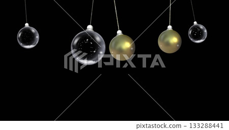 Hanging five Christmas baubles on cords swinging against black backdrop, with gold and star motifs Hanging five Christmas baubles on cords swinging against black backdrop, with gold and star motifs 133288441
