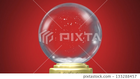 Glinting glass snow globe displaying swirling artificial snow flakes in studio, with gold base Glinting glass snow globe displaying swirling artificial snow flakes in studio, with gold base 133288457