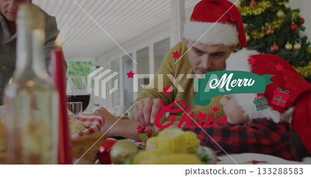 Father and son wearing Santa hats arranging ornaments in sunroom, with candles, copy space 133288583
