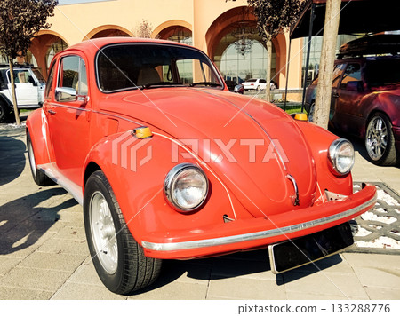 a red classic small car at an exhibition on a sunny day a red classic small car at an exhibition on a sunny day 133288776