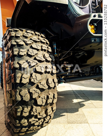 close up of a huge mud tire of an suv with deep tread 133288782