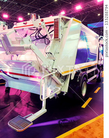 the rear part of a modern white garbage truck with a lifting mechanism at an exhibition 133288794